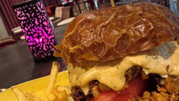 A close-up of a burger with fries on a yellow plate.