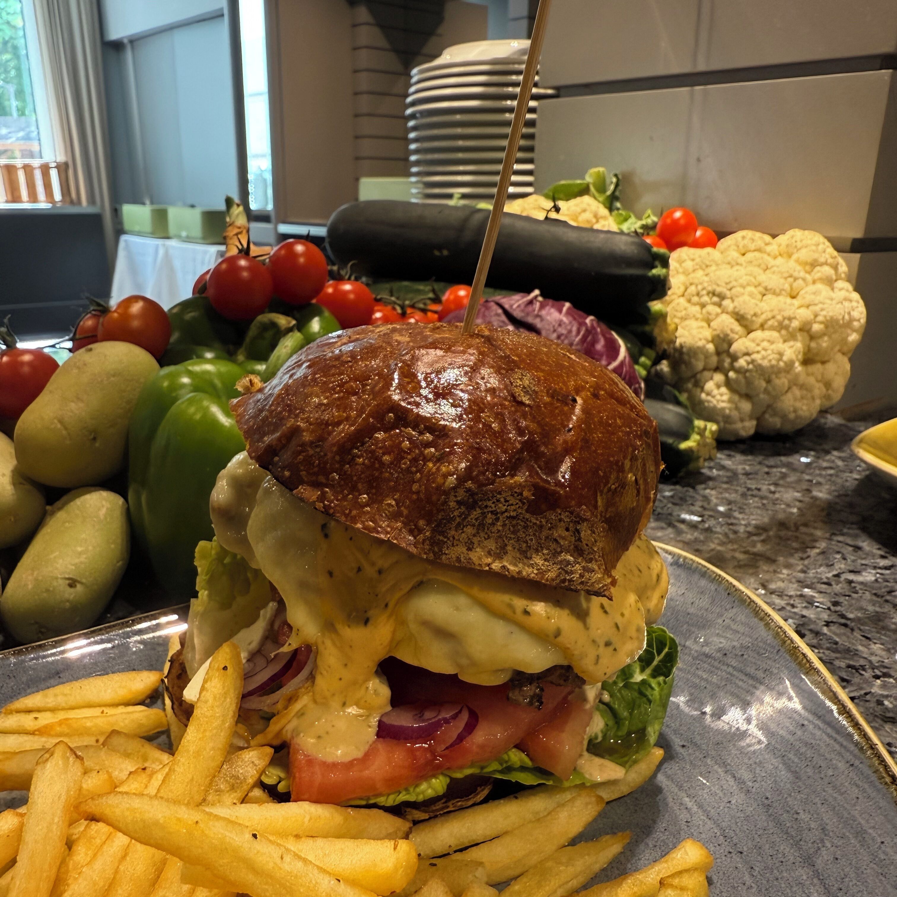 Un sándwich con pan tostado, lechuga, tomate y queso, acompañado de papas fritas en un plato.