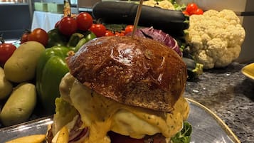 Un sándwich con pan tostado, lechuga, tomate y queso, acompañado de papas fritas en un plato.