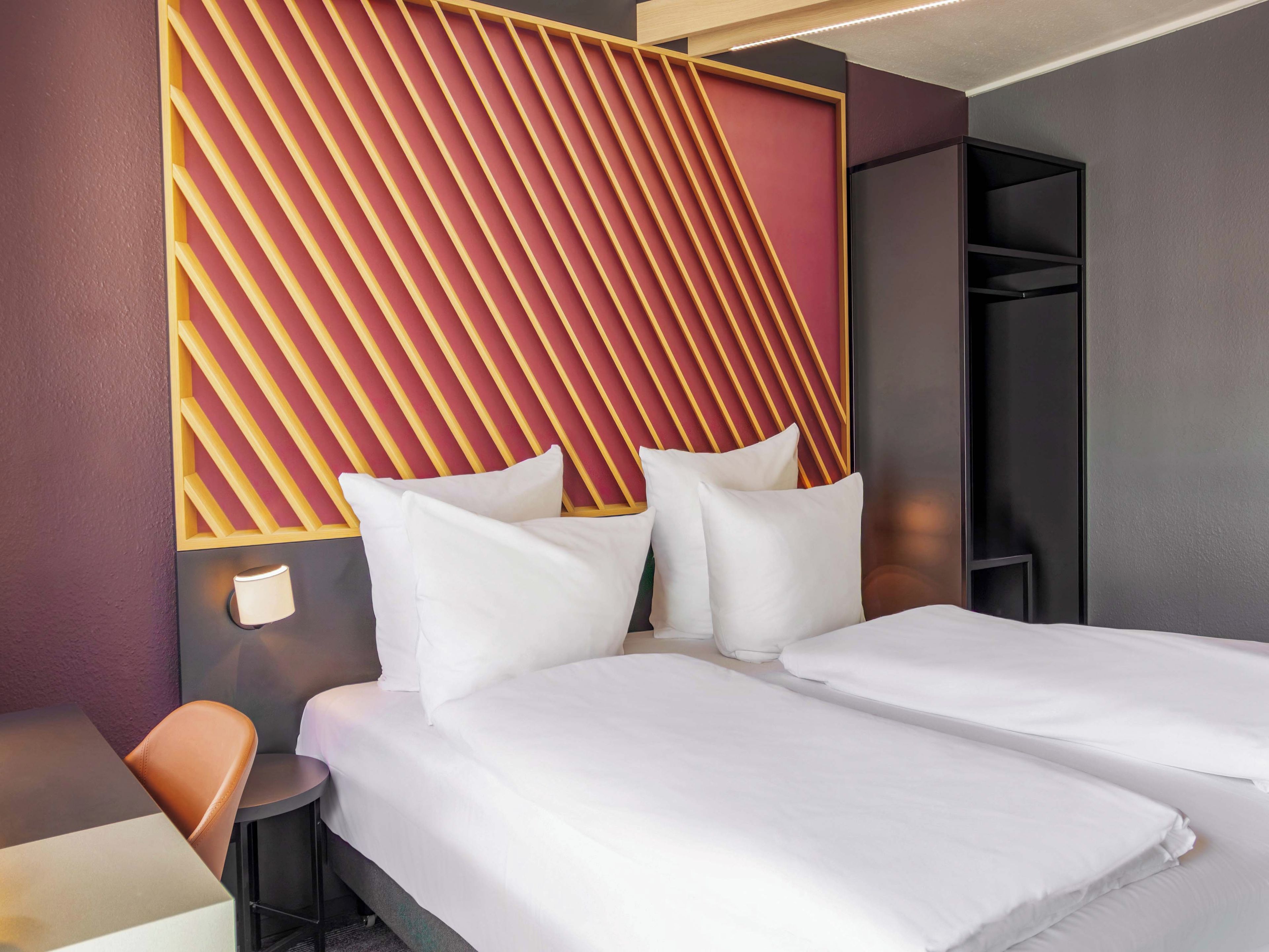 Una habitación de hotel con dos camas, una zona de estar y un armario.