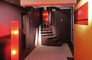 Experience the sleek, inviting atmosphere of our lobby, featuring a contemporary staircase and striking artwork.