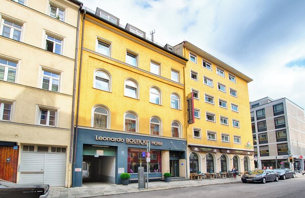 Un hotel con varios pisos, una entrada a nivel de calle y el cartel visible del Hotel Boutique Leonardo.