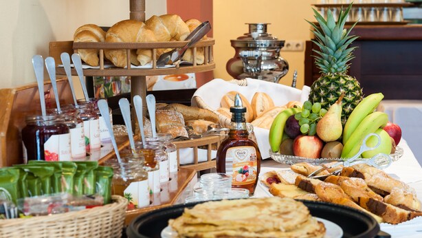 A breakfast buffet with various pastries, fruits, and condiments. - Hotel Antares (Munich)