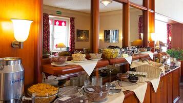 Una mesa de buffet con diversas opciones de comida y una estación de café.