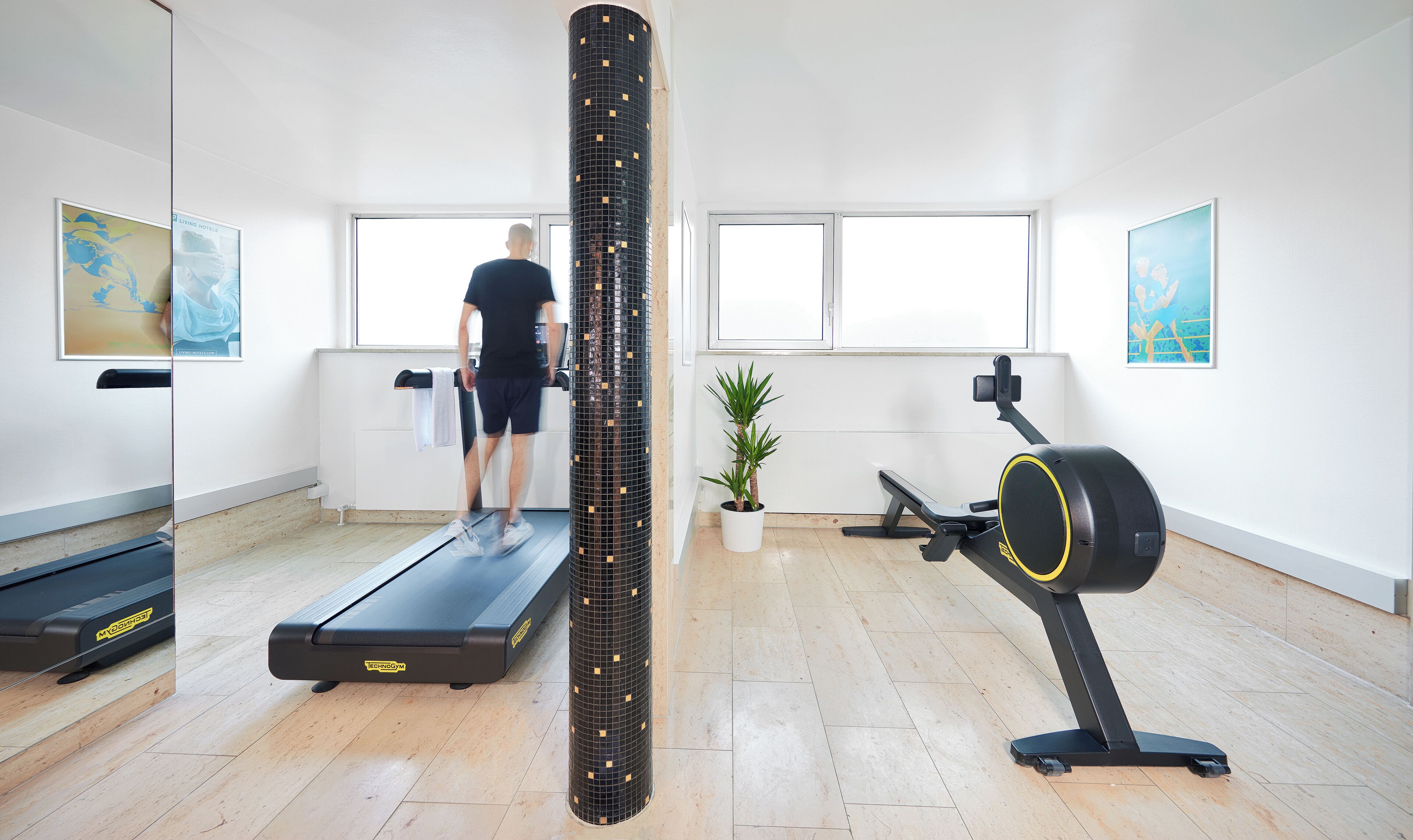 A gym with a treadmill, a stationary bike, and a large mirror.