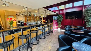 A bar area with a counter, stools, and a seating area with tables and chairs.