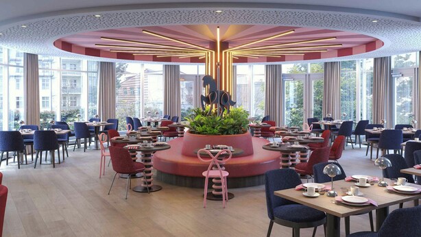 Un restaurant moderne doté d’un espace de restauration central, de grandes fenêtres et d’un plafond décoratif.