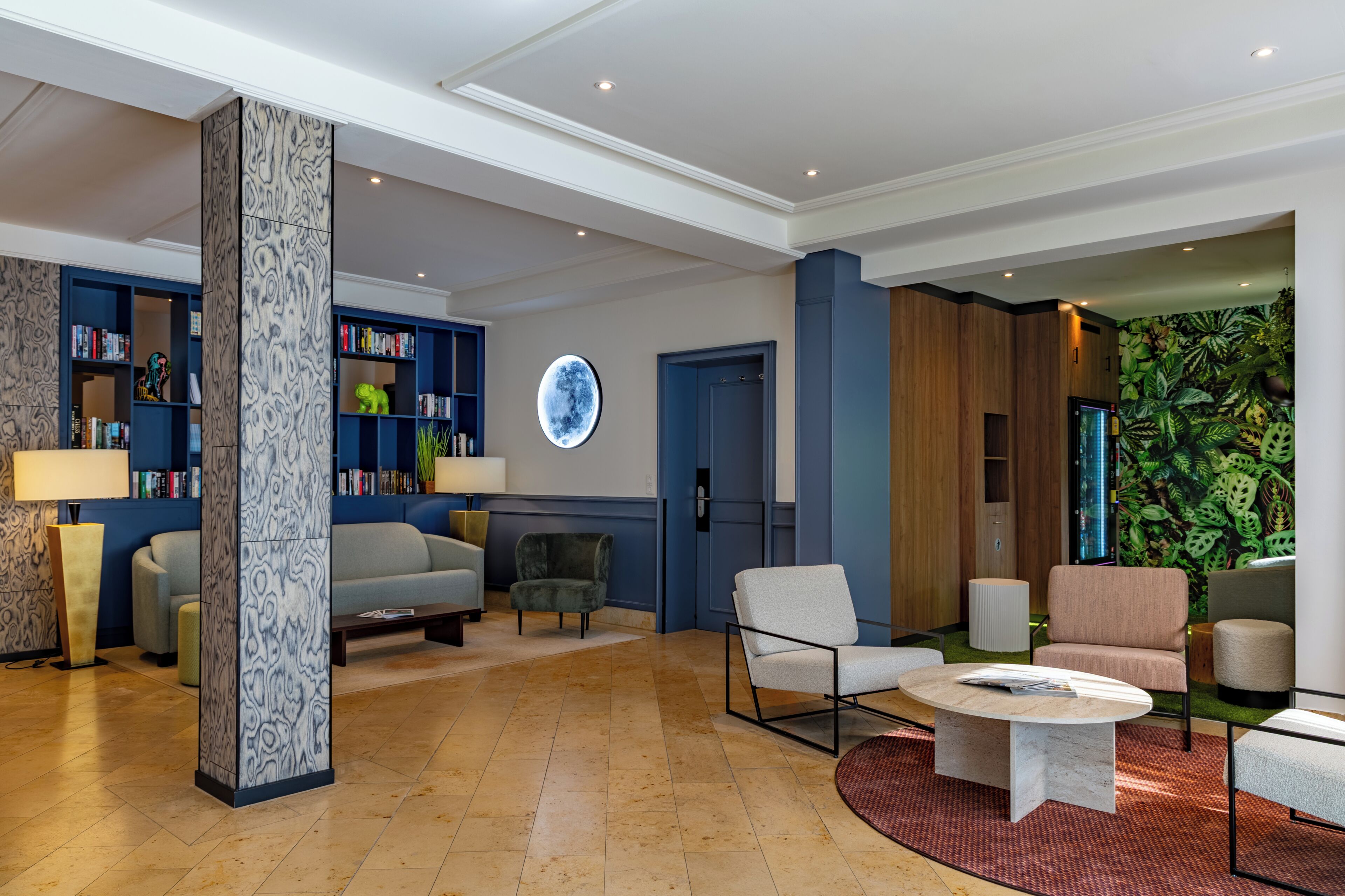 Un vestíbulo moderno con un sofá, sillones, una mesita de centro, una estantería y una pared con un diseño circular.