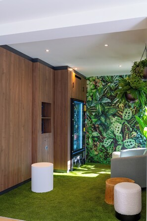 Een moderne woonkamer met een houten accentmuur, een flatscreen televisie, een bank en een vloer van kunstmatig gras.