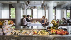 A breakfast buffet with various food items and a group of people dining. - Hotel Berlin (Sindelfingen)