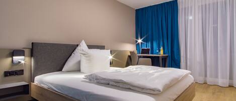 Hypo-allergenic bedding, desk, laptop workspace, blackout curtains
