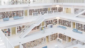 Een meerlaagse bibliotheek met boekenkasten, trappen en zitplekken.