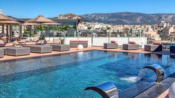 Una piscina al aire libre, una piscina climatizada, sombrillas