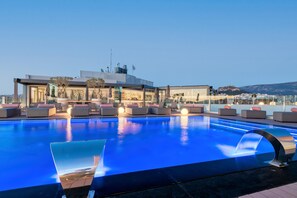 Una piscina al aire libre, una piscina climatizada, sombrillas