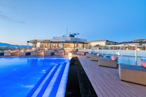 Una piscina al aire libre, una piscina climatizada, sombrillas