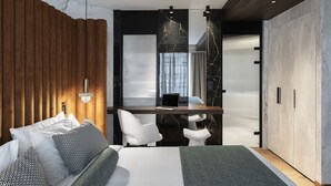 A modern bedroom with a bed, a desk, and a wardrobe.