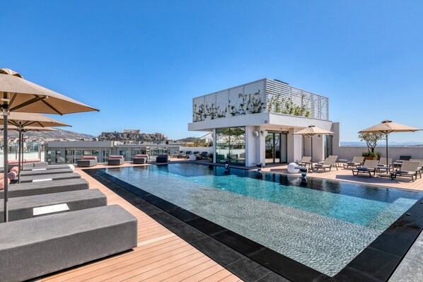 Una piscina al aire libre, una piscina climatizada, sombrillas