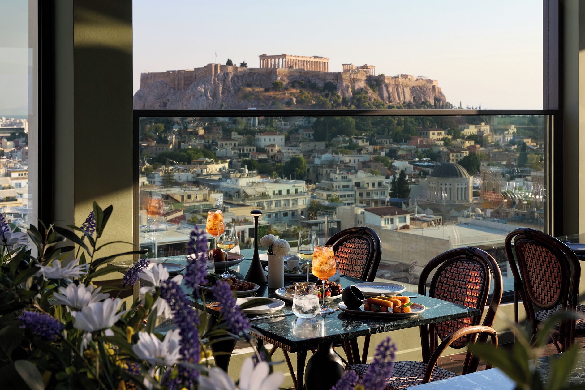 Une table dressée pour le dîner, avec vue sur un bâtiment historique situé sur une colline.
