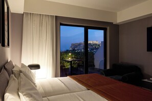 Quarto de hotel com uma cama, uma escrivaninha e vista para um edifício histórico.