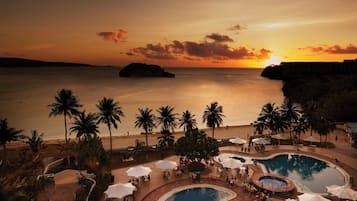 2 albercas al aire libre y sombrillas en la alberca