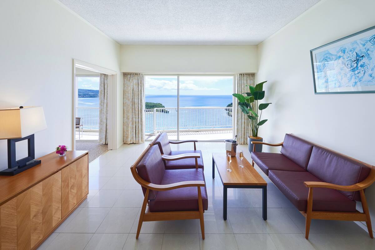 A modern living room with a sofa, a coffee table, and a TV on a wooden cabinet.
