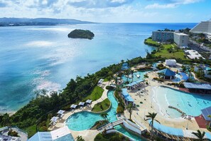 A resort with multiple swimming pools, a beach area, and a view of the ocean.