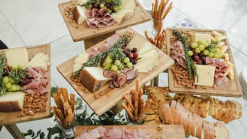 Variedad de quesos, carnes y pan sobre tablas de madera, dispuestas sobre una mesa.