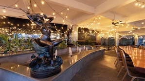 A modern hotel lobby with a central fountain, seating area, and string lights. - Copantl Hotel & Convention Center (San Pedro Sula)