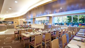A modern dining area with multiple tables and chairs, a buffet counter, and large windows offering a view of the outdoors. - The Cityview - Chinese YMCA of Hong Kong (Kowloon)