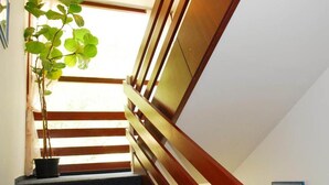 A staircase with wooden handrails and a potted plant on the left. - Hotel Orion (Budapest)