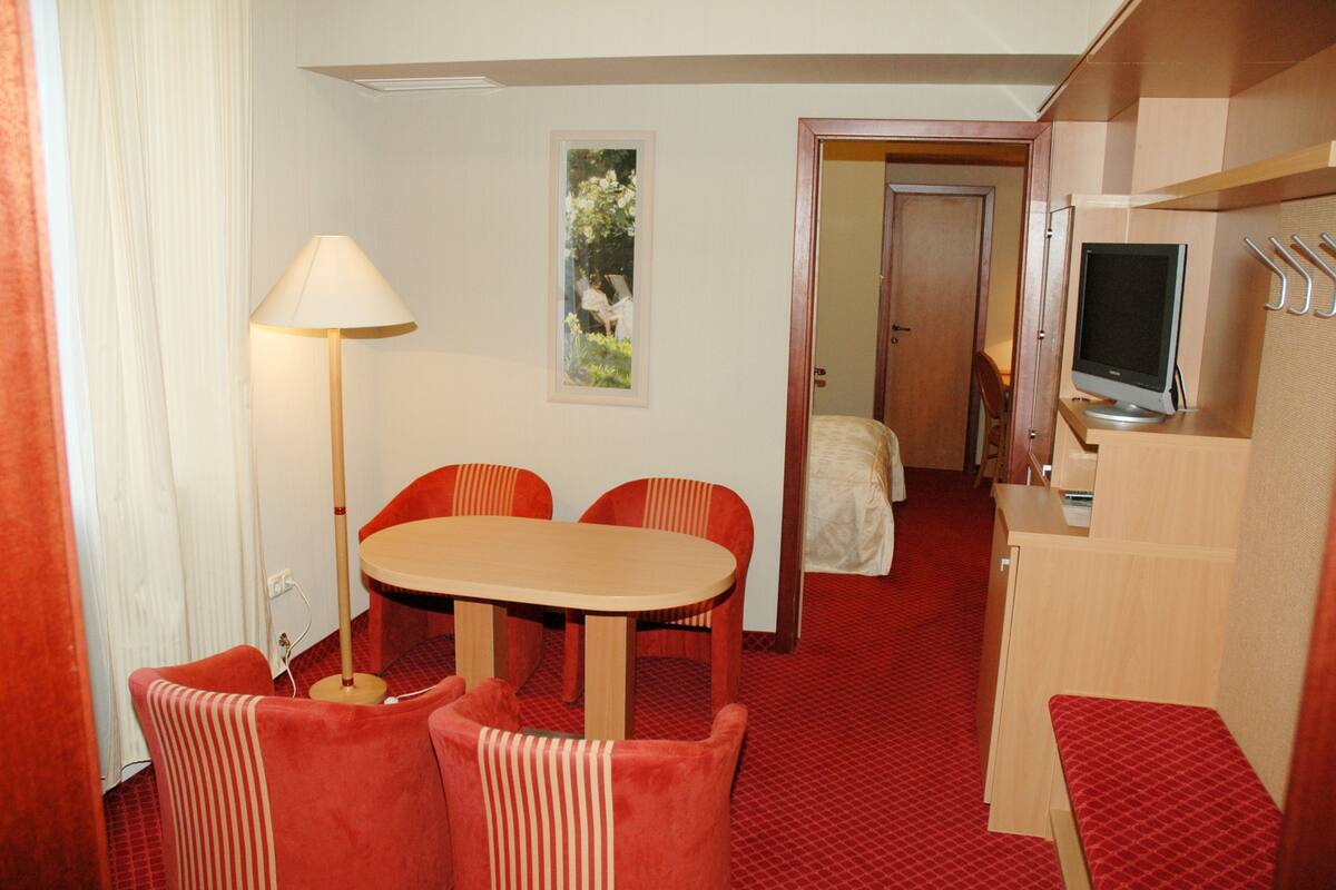 Une chambre d’hôtel comprenant un coin repas, une télévision et un lit.