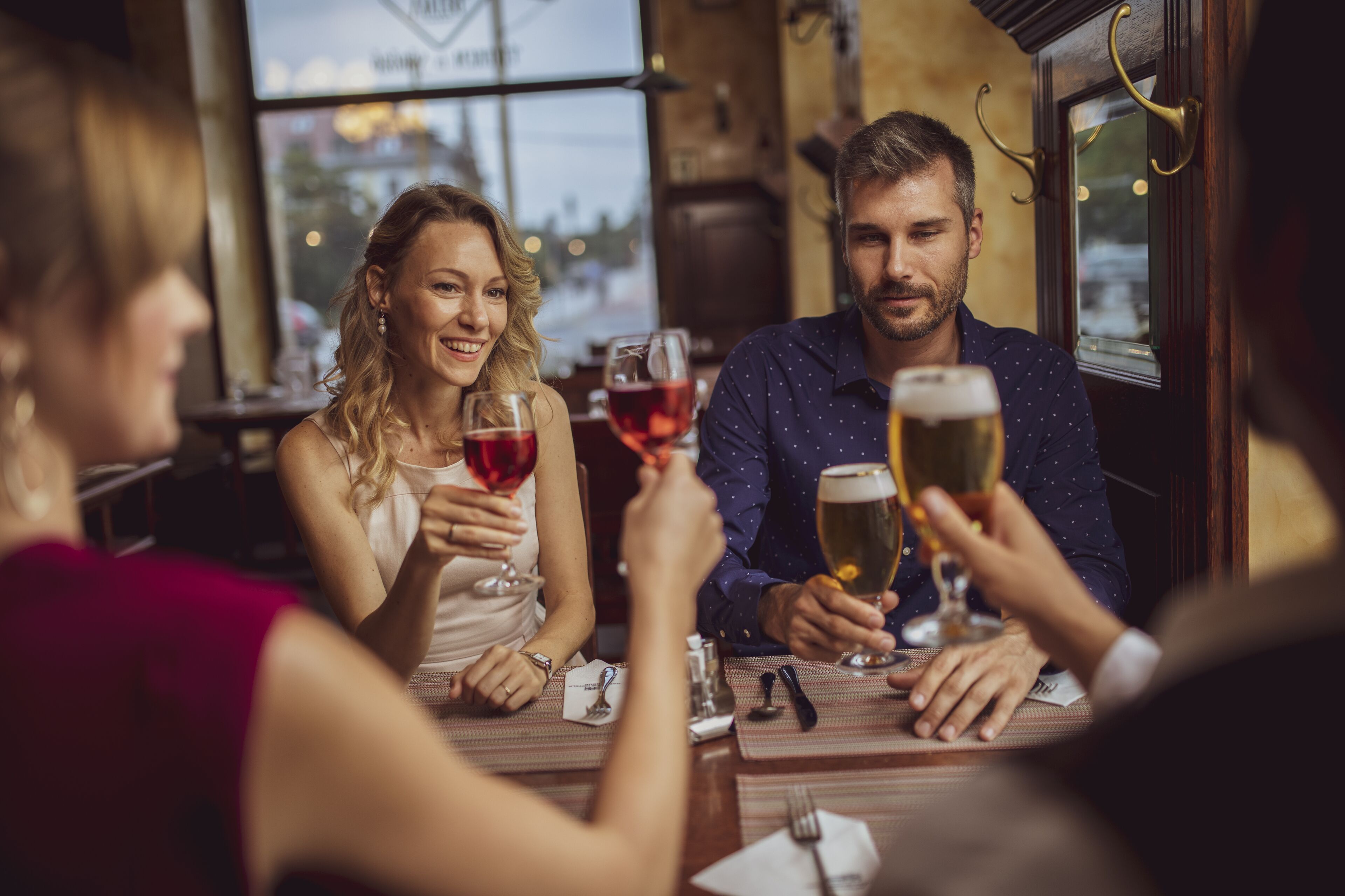 Un grupo de personas sentadas en una mesa en un restaurante con vistas a la ciudad a través de amplios ventanales.