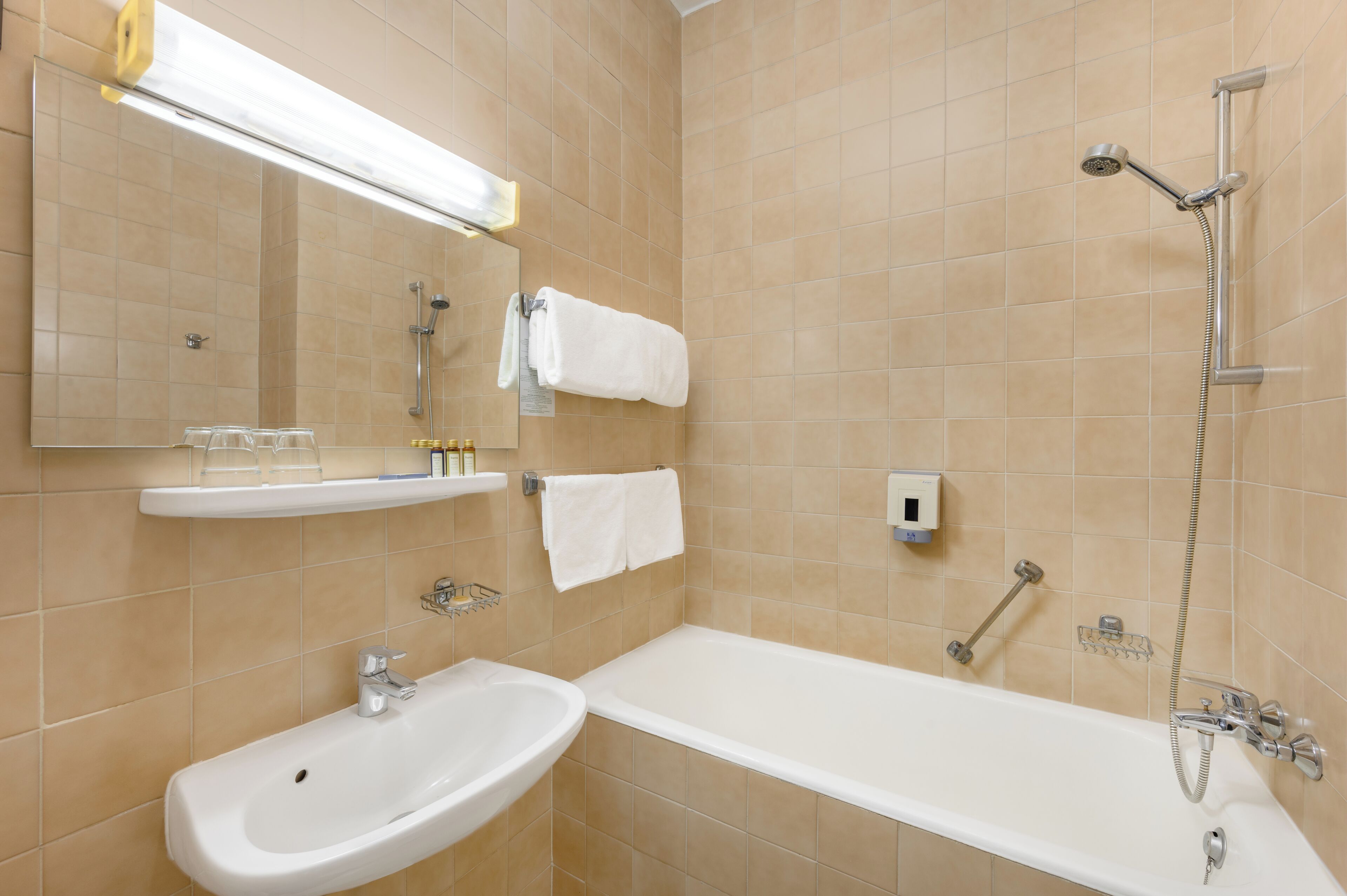 Une salle de bain moderne avec une baignoire, un lavabo, un miroir et une douche.