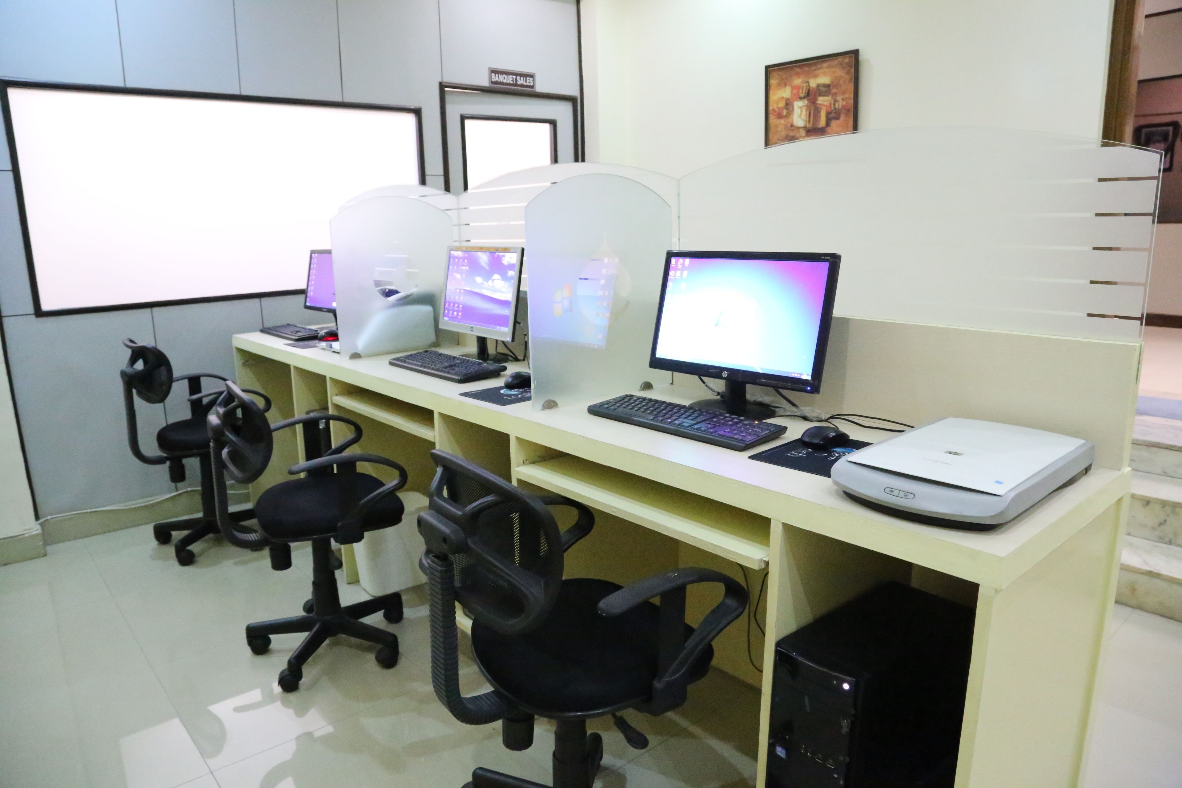 Un bureau moderne avec des cloisons, des ordinateurs et des chaises de bureau.