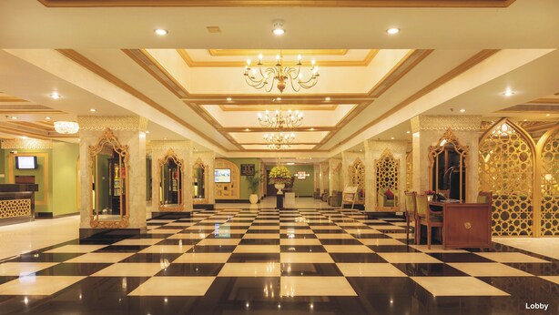 A lobby with a checkered floor, chandeliers, ornate mirrors, and a reception desk. - Hotel Clarks Shiraz (Agra)