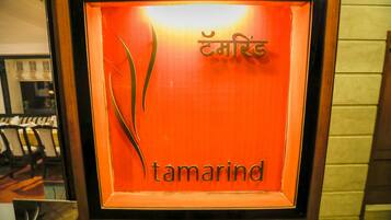 Ein gerahmtes Schild mit dem Schriftzug "tamarind" und einem dekorativen Element.
