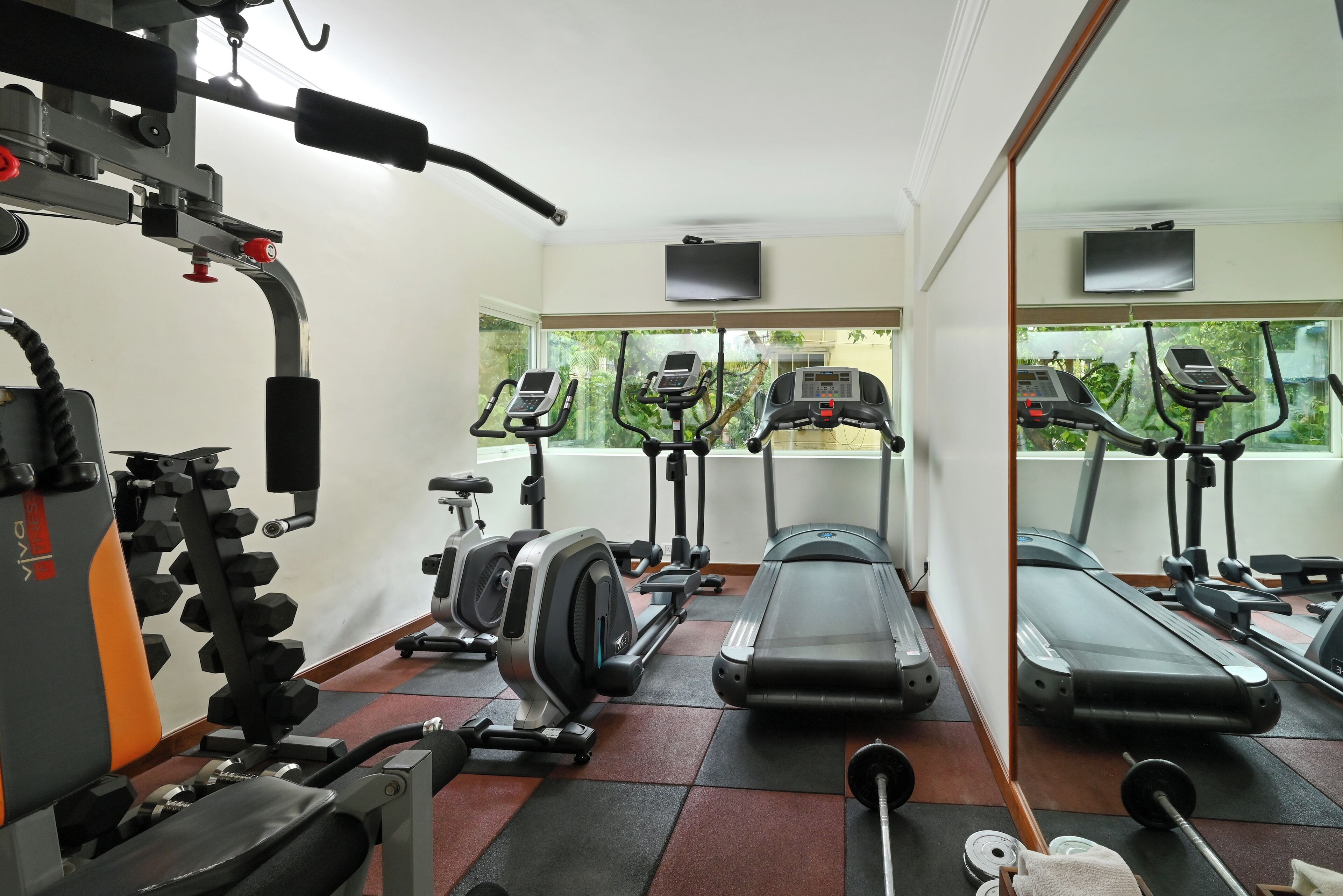 A gym with treadmills, elliptical machines, and weightlifting equipment.