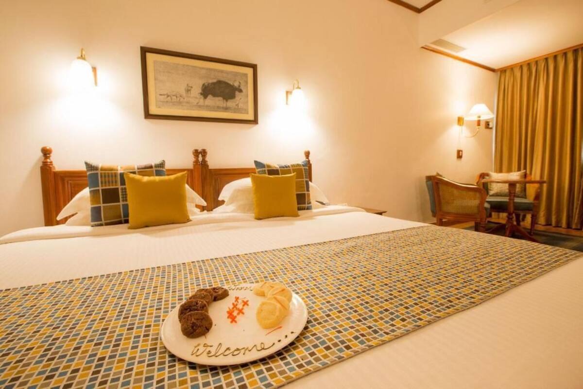 Una habitación de hotel con una cama, una mesa de comedor y un plato de comida, y una silla.