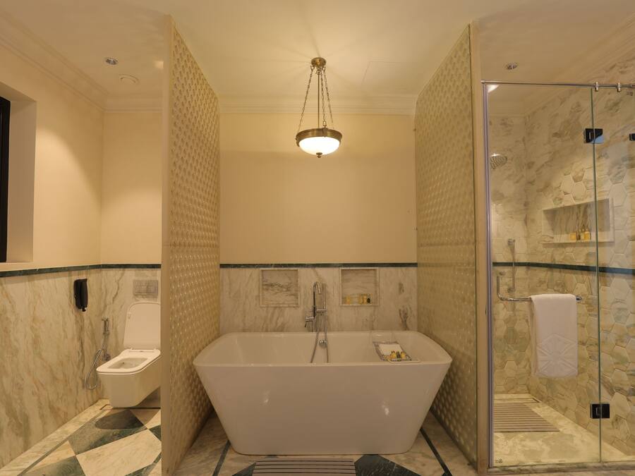 A modern bathroom with a freestanding bathtub, a glass-enclosed shower, and a marble-tiled floor.