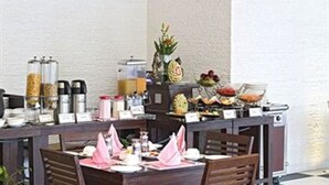 A breakfast buffet setup with various food items and beverages.