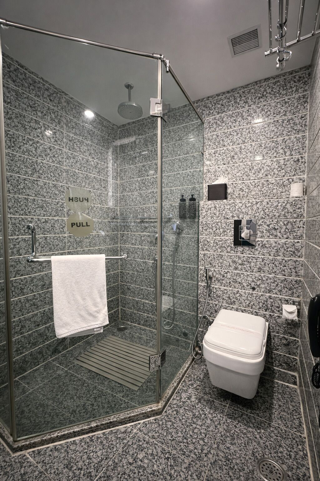 Un baño moderno con ducha de vidrio, inodoro y lavamanos.