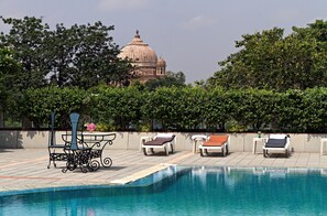 Una piscina al aire libre, sillones reclinables de piscina