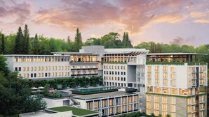 A modern hotel with multiple floors, a rooftop pool, and lush greenery surrounding the property. - Padma Hotel Bandung (Bandung)