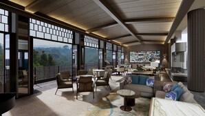 A spacious lounge with a large TV wall, comfortable seating, and a view of the mountains. - Padma Hotel Bandung (Bandung)