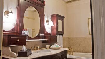 Ein Badezimmer mit großem Spiegel, Waschbecken, Badewanne und einem Schminktisch mit Schubladen und Spiegel.