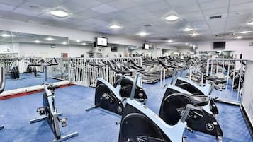 A gym with multiple treadmills, exercise bikes, and weight machines.