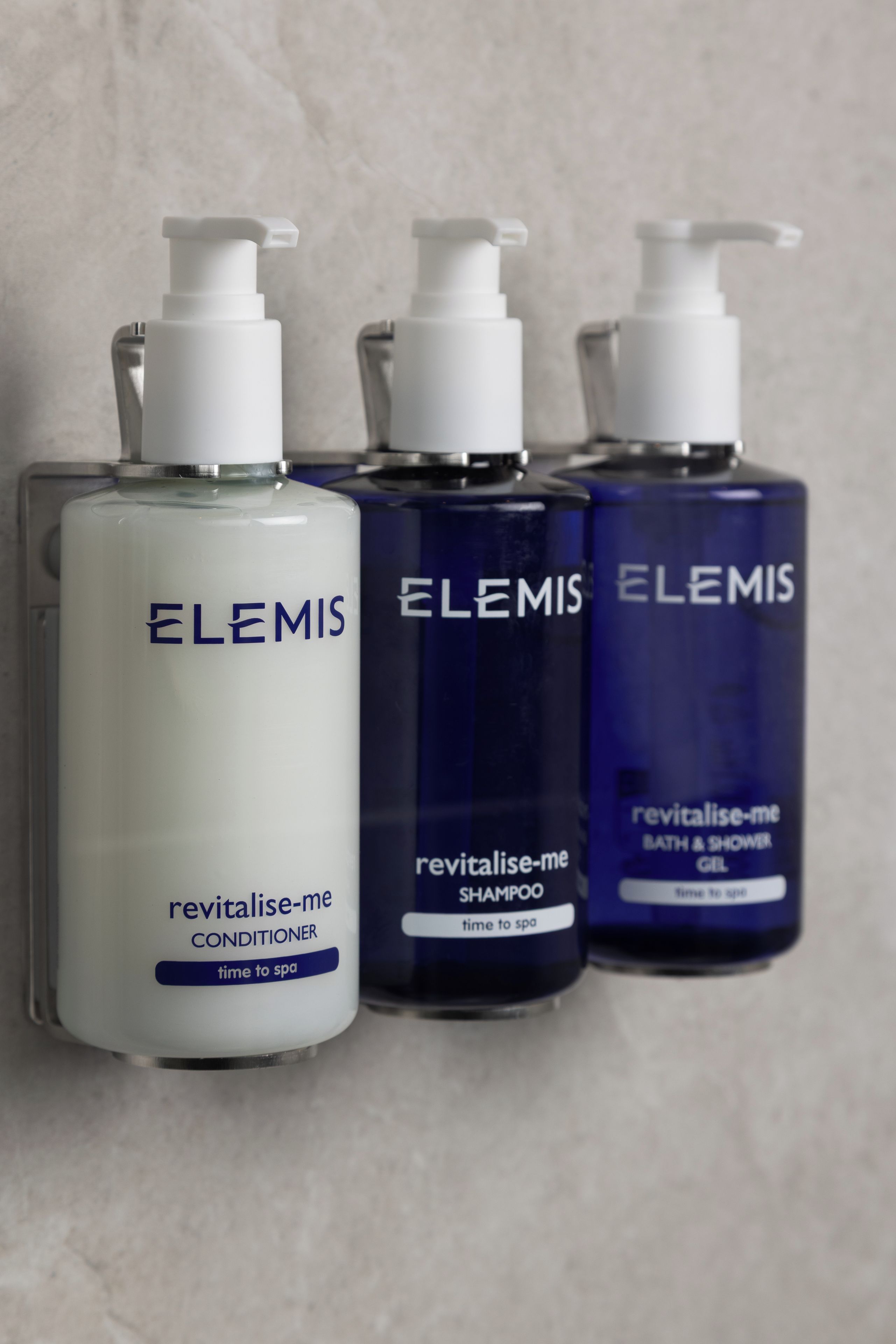 Three bottles of Elemis Revitalise-me products: conditioner, shampoo, and bath & shower gel.