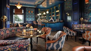 Een bar met zitplaatsen, een barman en een bar.