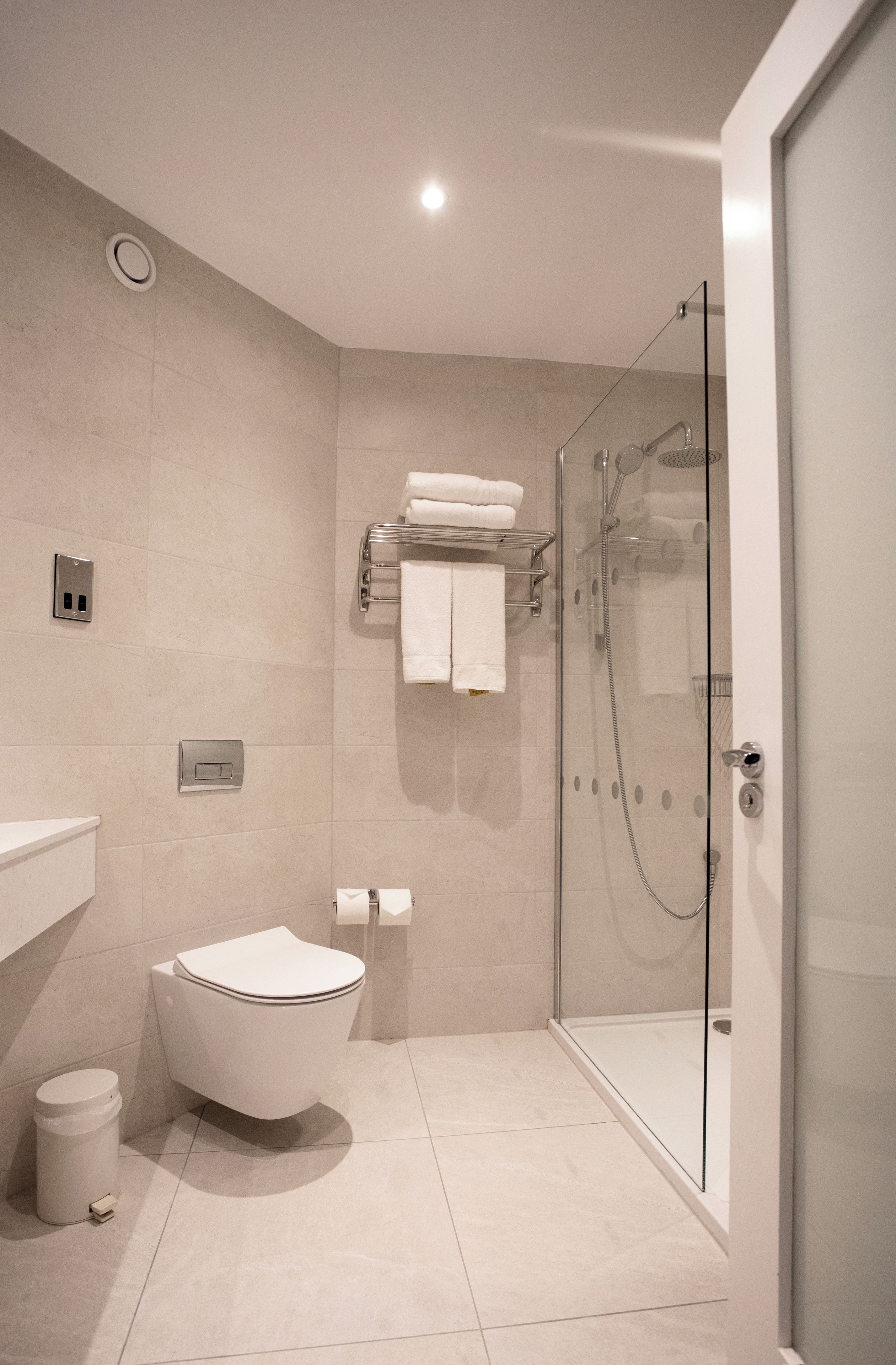 A modern bathroom with a freestanding bathtub, a glass-enclosed shower, and a toilet.