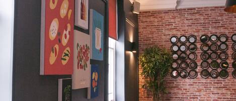 A restaurant interior with a brick wall, framed artwork, and a wall of circular mirrors.